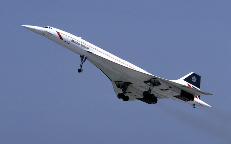 British Airways Concorde taking off, nose up with landing gear down against a clear blue sky