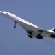 British Airways Concorde taking off, nose up with landing gear down against a clear blue sky
