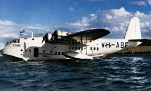 White amphibious transport aircraft on calm water, Qantas Empire Airways Brisbane inscription visible on fuselage, registration C00EE.